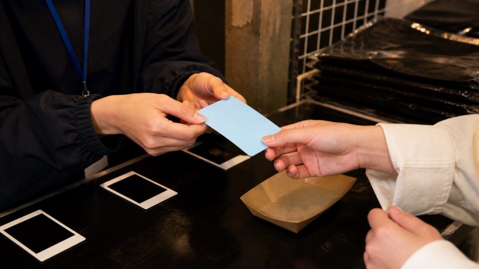 物販カウンターで無地のカードを受け取る場面